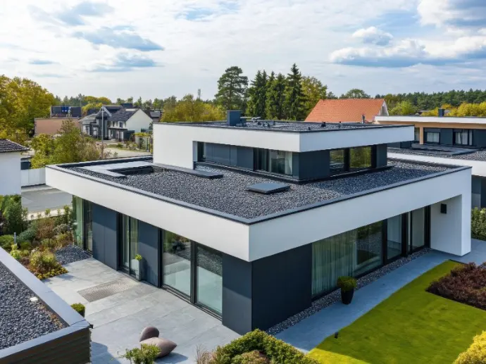 Modernes Wohnhaus mit Flachdach inklusive Kiesschicht und Dachfenstern – professionelle Abdichtung durch Schwarzdecker